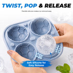 Flexible silicone tray being twisted to release a soccer ball ice cube